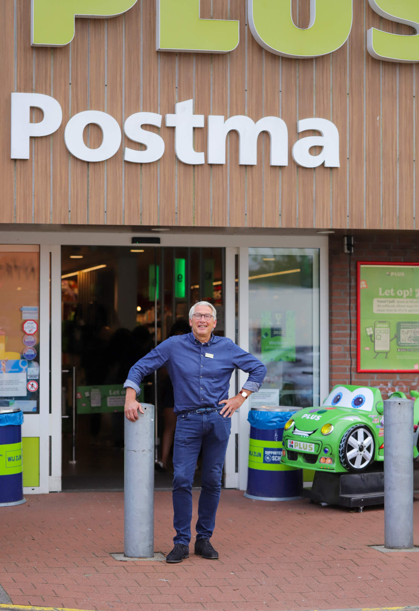 Eigenaar Jan van de PLUS supermarkt in Lelystad staat voor de ingang van de winkel